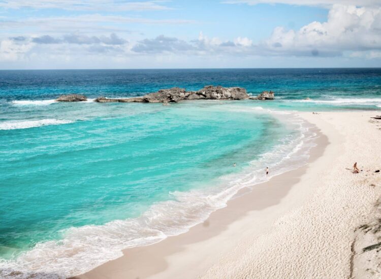Mudjin,Harbour,,Turks,And,Caicos,Islands,-,December,29,2023: Mudjin Harbour, Turks and Caicos Islands - December 29 2023: A handful of tourists play in the waves at Mudjin Harbour, a secluded beach on the larger island of Middle Caicos in the archipelago.